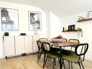 a dining room with a table and chairs and the eiffel tower at New Disneyland Paris Serena Apartment in Bussy-Saint-Georges