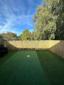 a backyard with a fence and a green lawn at *CASA Iguazu* in Cholet