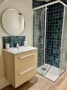 a bathroom with a sink and a shower with a mirror at *CASA Iguazu* in Cholet