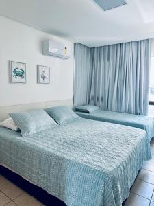 two beds in a hotel room with blue sheets at Bangalô Boutique com piscina Privativa - 3 Suítes in Porto De Galinhas +30 photos