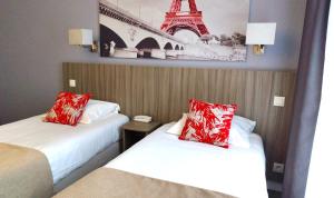 two beds in a hotel room with a picture of the eiffel tower at Avia H&ocirc;tel Saphir Montparnasse in Paris