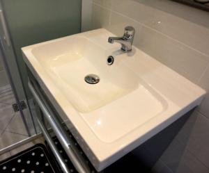 a white bathroom sink with a faucet at Maison hôtes près de Disneyland Paris in Lagny +3 photos