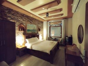 尼茲瓦的住宿－Durrat Nizwa Hotel，一间卧室设有一张大床和砖墙
