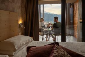 a man and woman sitting at a table in a hotel room at Miravalle in San Lorenzo in Banale