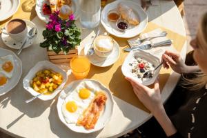 uma mesa com pratos de café da manhã e uma mulher comendo em Miravalle em San Lorenzo in Banale mais 67 fotografias