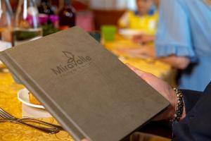 uma pessoa segurando um cardápio em cima de uma mesa em Miravalle em San Lorenzo in Banale