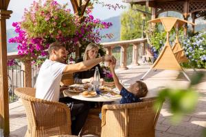 una familia cenando en una mesa en un patio en Miravalle, en San Lorenzo in Banale