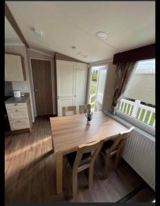 a dining room with a wooden table and a window at Miss Pollys Hideaway in Port Seton