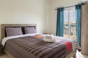een slaapkamer met een bed met handdoeken erop bij Secret Oasis Aptms room 2 in Larisa