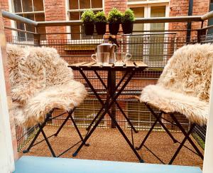 a small table with two chairs on a balcony at The Fifth Quarters, Grade II Listed Apartment, The Lace Market, NG1, City Centre, Nottingham, Sleeps 4 in Nottingham +41 photos