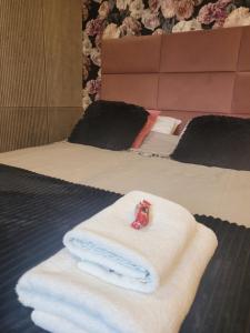 a pile of towels sitting on top of a bed at Apartament w sercu Elbląga in Elblag