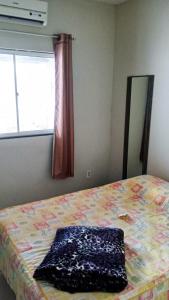 una camera con letto, specchio e finestra di Casa MD a Camocim