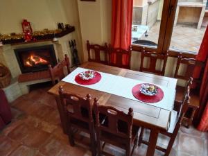 comedor con mesa y chimenea en Villa Villen en Moclín