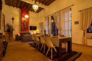 uma grande sala de estar com mesa e cadeiras em Villa Septha em Marrakech