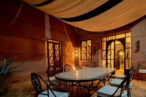 uma sala de jantar com mesa e cadeiras em Villa Septha em Marrakech
