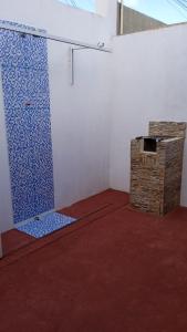 una camera con doccia e piastrelle blu sul muro di Casa MD a Camocim