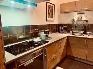 een keuken met een fornuis bovenoven naast een gootsteen bij The Fifth Quarters, Grade II Listed Apartment, The Lace Market, NG1, City Centre, Nottingham, Sleeps 4 in Nottingham