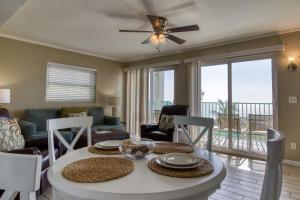 a living room with a table and chairs and a balcony at The New Hotel Collection Beachfront in Clearwater Beach
