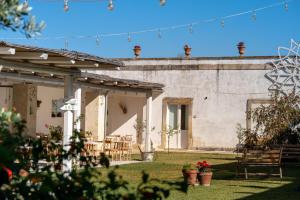 an external view of a building with tables and chairs at Masseria Rauccio in Torre dell'Orso