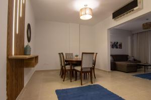 a living room with a table and chairs and a couch at Luxurious NEW CAIRO Mirage City 1 BRD Apartment in Cairo