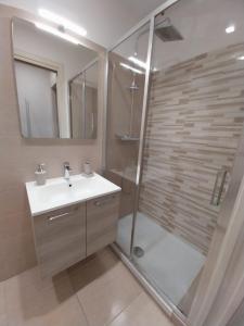 uma casa de banho com um chuveiro, um lavatório e um espelho. em Il covo dei Briganti em Roma