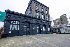 a black building with a door in a parking lot at Deluxe Urban Retreat with City Views Studio and One Bedroom Apartments near Camden by Belvilla in London