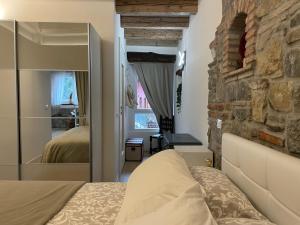 a bedroom with a bed and a stone wall at L'angolo di Filippo I in Cividale del Friuli