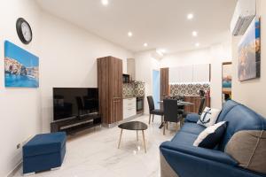 un soggiorno con un divano blu e un tavolo di Aloha - Village Apartment 2 BR in Mellieha a Mellieħa