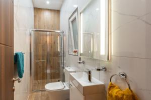 a bathroom with a sink and a shower and a toilet at Aloha - Village Apartment 2 BR in Mellieha in Mellieħa