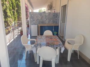 a dining room with a table and white chairs at Vulcano: La Porta Delle Eolie 2.0 in Vulcano