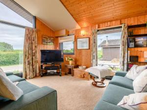 a living room with a blue couch and a television at 3 Bed in Ullswater 88212 in Tirril