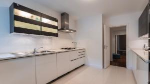 een witte keuken met witte kasten en een wastafel bij Classy 3BDR Property by LovelyStay in Lissabon