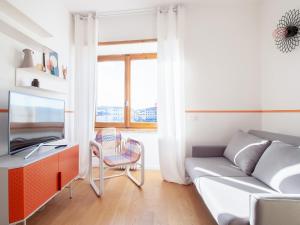 ein Wohnzimmer mit einem Sofa und einem TV in der Unterkunft Alinari Boutique Apartments in Florenz