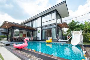 a house with a swimming pool with inflatable flamingos at 94 Pool Villa in Ban Huai Yai