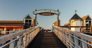 a boardwalk with a sign that reads presbyterians village at Steveston Waterfront Hotel in Richmond