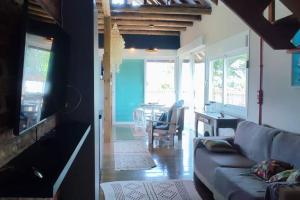 Deslumbrante Casa Frente Lagoa في بالنياريو بارا دو سول: غرفة معيشة مع أريكة وغرفة طعام
