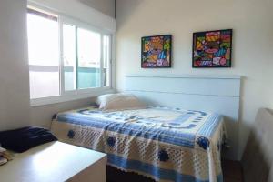 um pequeno quarto com uma cama e uma janela em Deslumbrante Casa Frente Lagoa em Balneario Barra do Sul