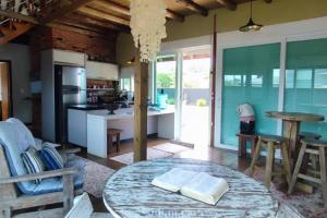 uma cozinha e sala de jantar com mesa e cadeiras em Deslumbrante Casa Frente Lagoa em Balneario Barra do Sul