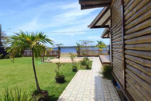 uma passagem ao lado de uma casa com uma palmeira em Deslumbrante Casa Frente Lagoa em Balneario Barra do Sul