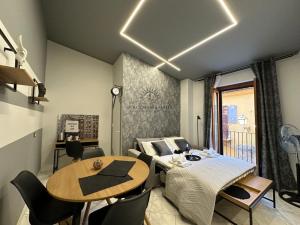 Dolce Marea Suites في ليكاتا: غرفة بسرير وطاولة وكراسي