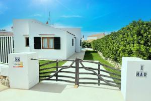 a white house with a gate and a fence at Villa Mar Uno in Cala'n Bosch