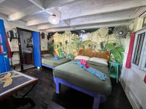Habitación con 2 camas y un mural en la pared. en Tesoro Escondido Ecolodge Cabinas en Bocas del Toro
