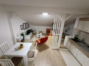 cocina y sala de estar con mesa blanca y cocina en Apartmani S - DSN, en Kraljevo