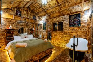 a bedroom in a wooden cabin with a bed and a tub at Riad Atlas Bangalo in Imlil