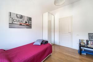 ein Schlafzimmer mit einem Bett mit einer rosa Decke in der Unterkunft appartamento luce del lago in Salò