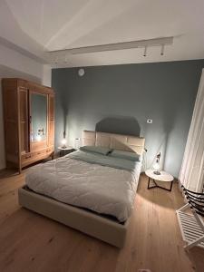 een slaapkamer met een groot bed en een blauwe muur bij AMIA rooms & wine in Valdobbiadene