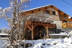 una casa in legno con balcone nella neve di Gite le Pré de Lamia a Chevenoz