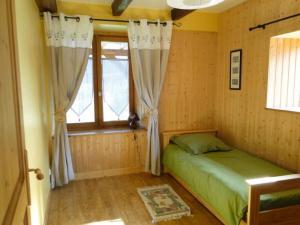 una camera con letto verde e finestra di Gite le Pré de Lamia a Chevenoz
