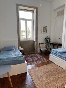 a bedroom with two beds and a window at Casa dos Caminhos de Santiago in Mosteiró