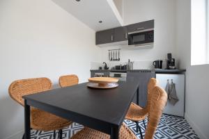 une cuisine avec une table et des chaises noires dans l'établissement Stunning flat in Paris, à Paris